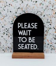 SIGN - PLEASE WAIT TO BE SEATED BLK ARCH