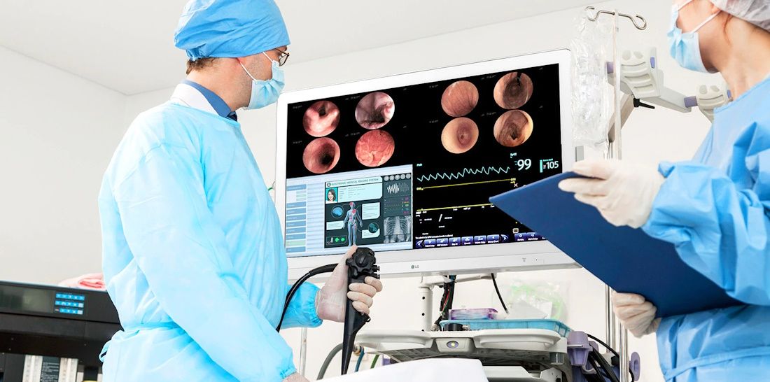 Picture of 2 surgeons beside LG surgical monitor