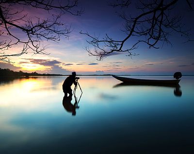 Man taking photograph on boat in water