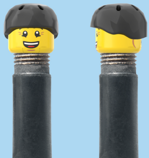 `A NEW ITEM  -  Brick Caps - Schrader Valve - 2 Face Head (Bursting Cheeks & Wrinkle Eye Smile) with a Black Helmet