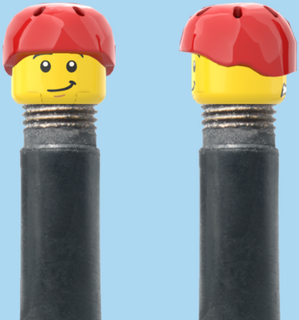 `A NEW ITEM  -  Brick Caps - Schrader Valve - 2 Face Head (Worried Look & Half Smile) with a Red Helmet