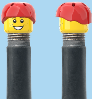 `A NEW ITEM  -  Brick Caps - Schrader Valve - 2 Face Head (Freckles Smile & Freckles Worried Look) with a Red Helmet