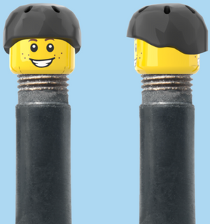 `A NEW ITEM  -  Brick Caps - Schrader Valve - 2 Face Head (Freckles Smile & Freckles Worried Look) with a Black Helmet
