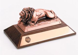 MODEL LION ON WOOD BASE