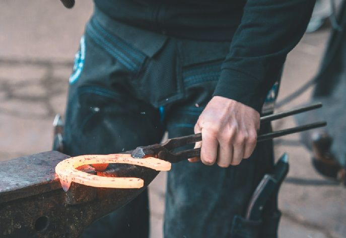 Hot shaping horseshoe on anvil