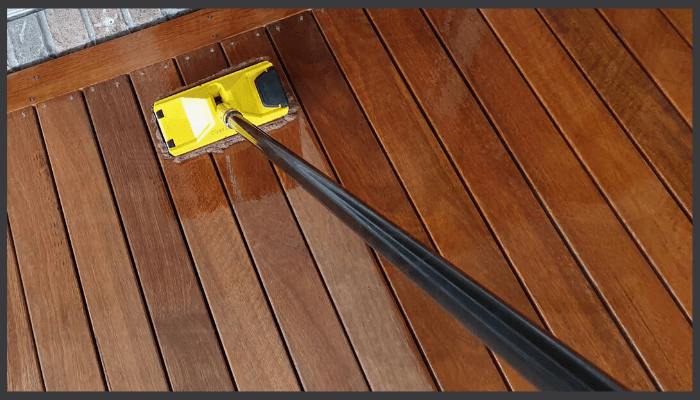 Decking oil being applied to spotted gum boards with applicator pad