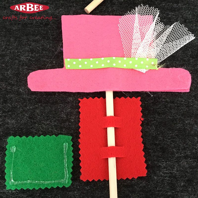Hot glue, felt pieces and a dowel rod
