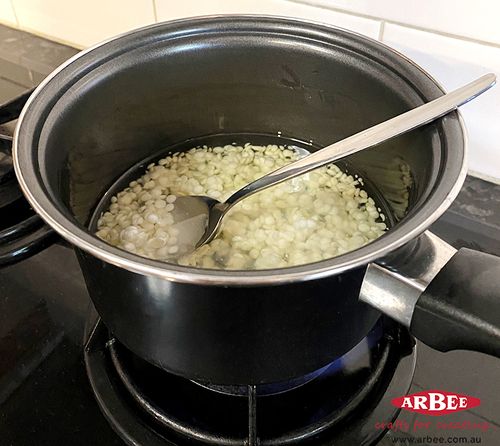 Wax pellets melting in a pot on the stove